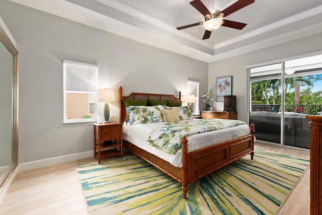 bedroom with wood-type flooring, a tray ceiling, ceiling fan, and ornamental molding