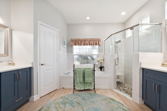 bathroom with vanity, a healthy amount of sunlight, wood-type flooring, and independent shower and bath