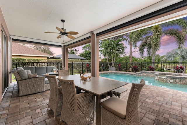 patio terrace at dusk featuring an in ground hot tub, ceiling fan, and an outdoor hangout area