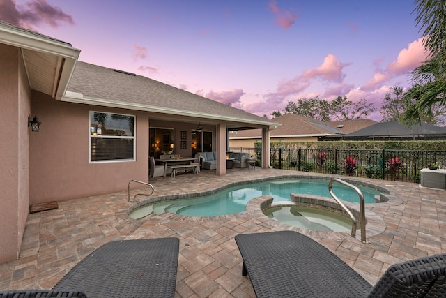 pool at dusk with an in ground hot tub, an outdoor hangout area, cooling unit, grilling area, and a patio area