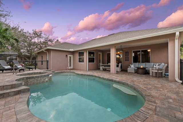 pool at dusk featuring an in ground hot tub, an outdoor hangout area, a patio, and ceiling fan