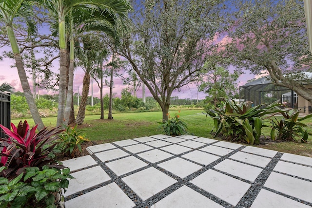 patio terrace at dusk with glass enclosure and a lawn