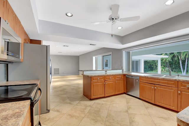 kitchen featuring sink, ceiling fan, light tile patterned floors, appliances with stainless steel finishes, and kitchen peninsula