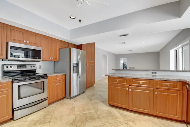 kitchen featuring light stone countertops, light tile patterned floors, and appliances with stainless steel finishes