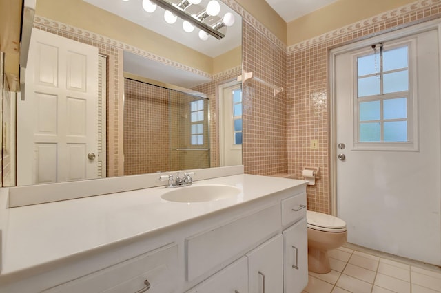 bathroom with tile patterned flooring, vanity, toilet, and a shower with shower door