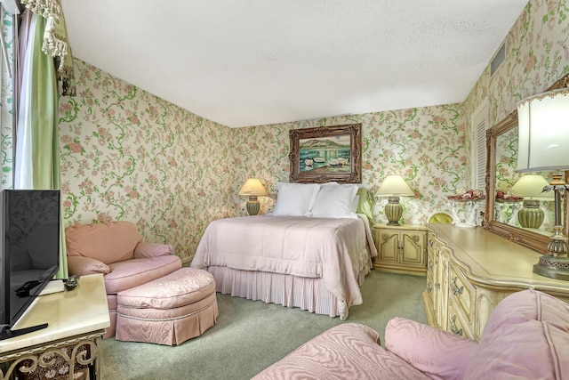 bedroom featuring light carpet and a textured ceiling