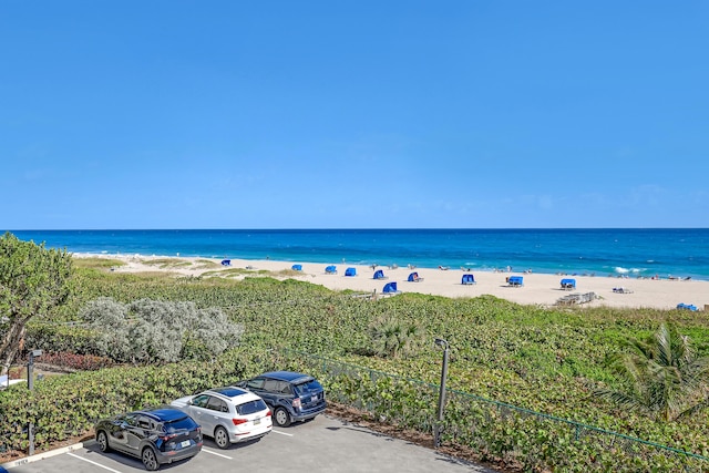 view of water feature with fence and a beach view