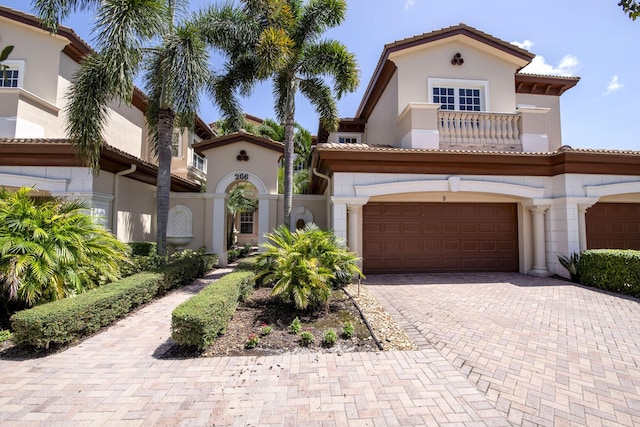 mediterranean / spanish house featuring a garage and a balcony