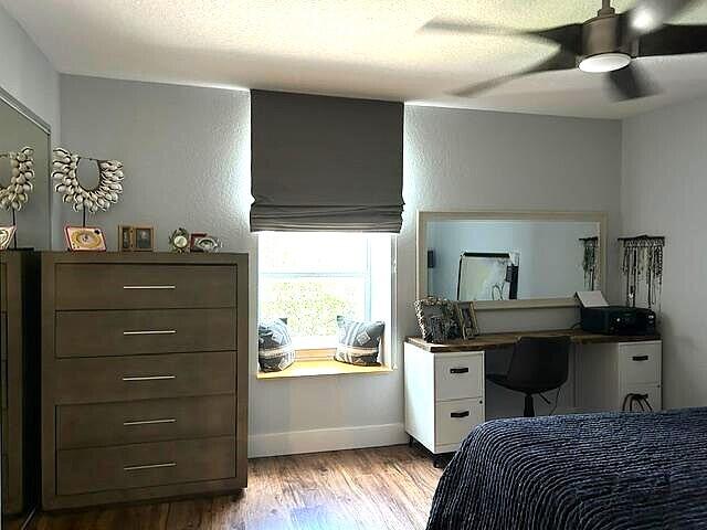 bedroom with ceiling fan, light hardwood / wood-style floors, and a textured ceiling