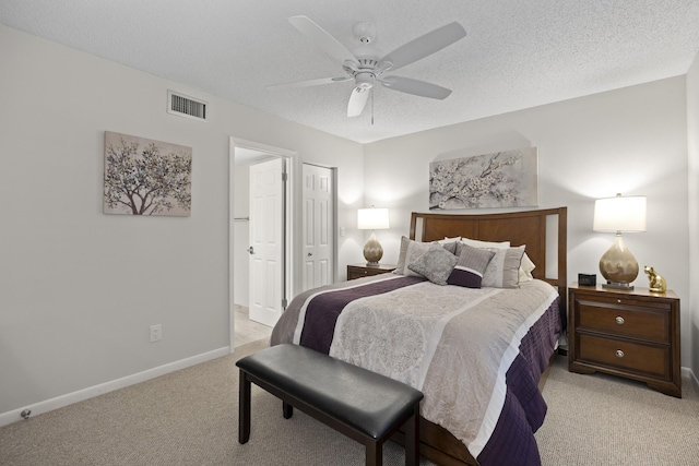 carpeted bedroom with a textured ceiling and ceiling fan