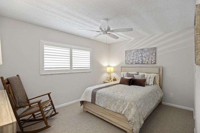 carpeted bedroom featuring ceiling fan and a textured ceiling