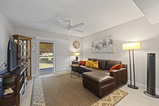 living room featuring ceiling fan and a textured ceiling