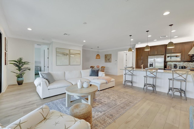 living room with crown molding and light hardwood / wood-style flooring