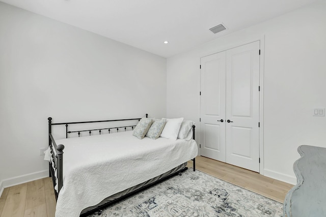 bedroom with wood-type flooring and a closet