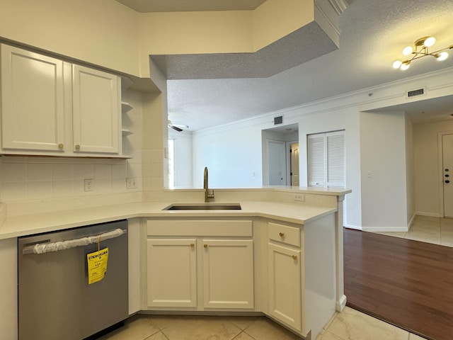 kitchen with white cabinets, dishwasher, kitchen peninsula, and sink