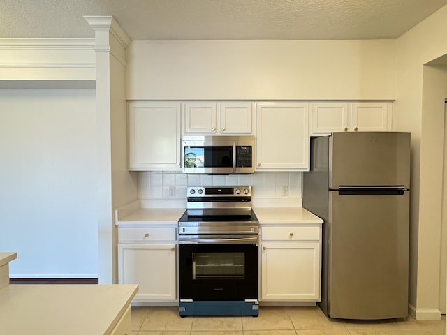 kitchen with tasteful backsplash, white cabinets, stainless steel appliances, and light tile patterned floors