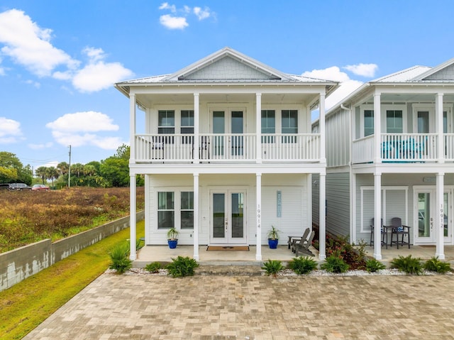 back of property featuring french doors and a balcony