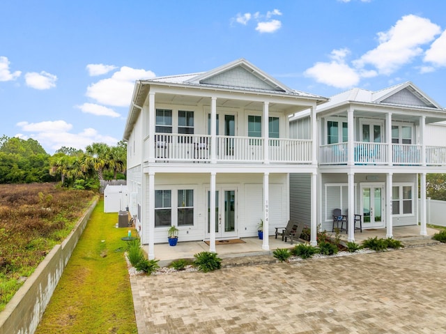 back of house featuring french doors, a patio, a balcony, and central AC