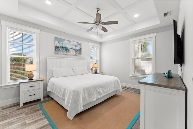 bedroom featuring ceiling fan, light hardwood / wood-style flooring, and coffered ceiling