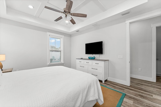 bedroom with ceiling fan, light hardwood / wood-style floors, and coffered ceiling