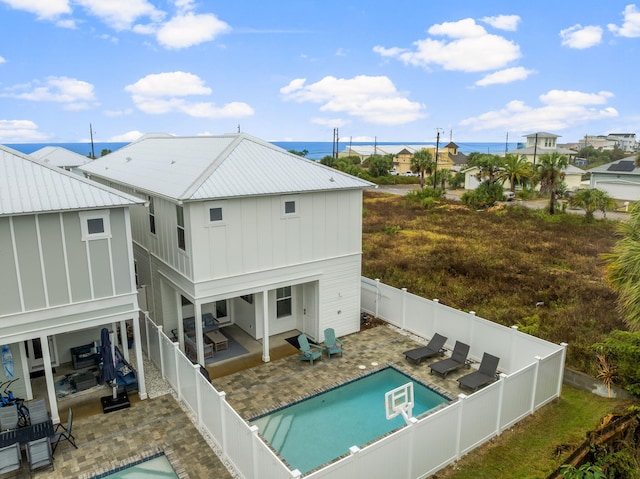 back of house featuring a fenced in pool and a patio