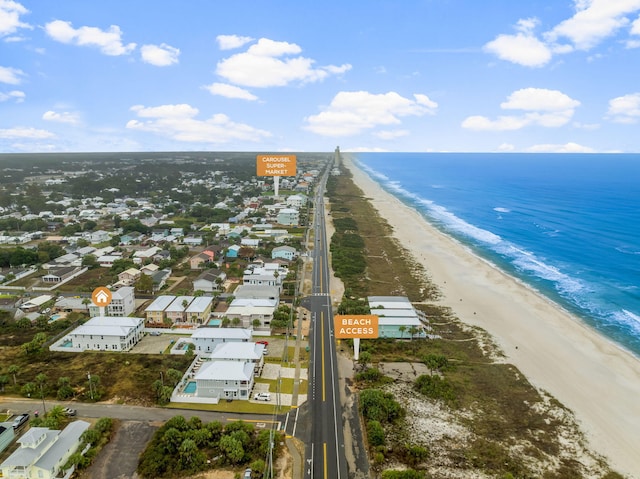 birds eye view of property with a water view and a beach view