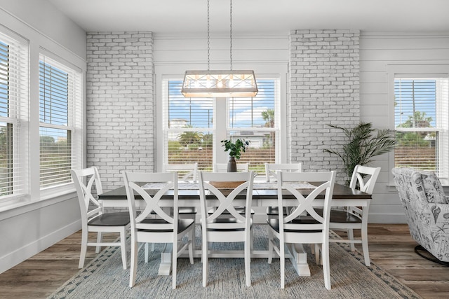 dining space featuring wood-type flooring and a healthy amount of sunlight