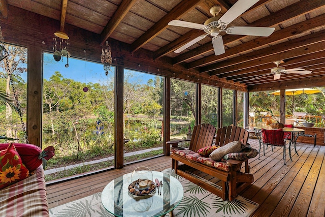 sunroom featuring beam ceiling, ceiling fan, a healthy amount of sunlight, and wood ceiling