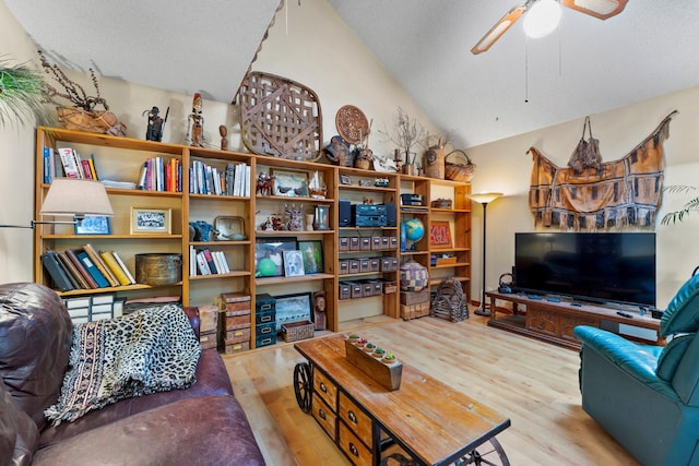 living room featuring ceiling fan, light hardwood / wood-style flooring, and vaulted ceiling