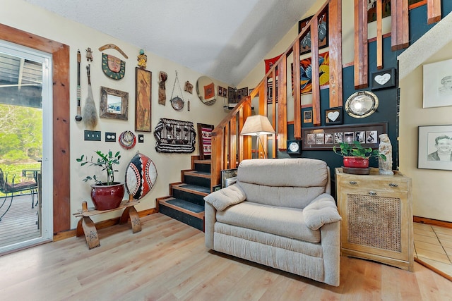 living area with hardwood / wood-style floors, a textured ceiling, and vaulted ceiling