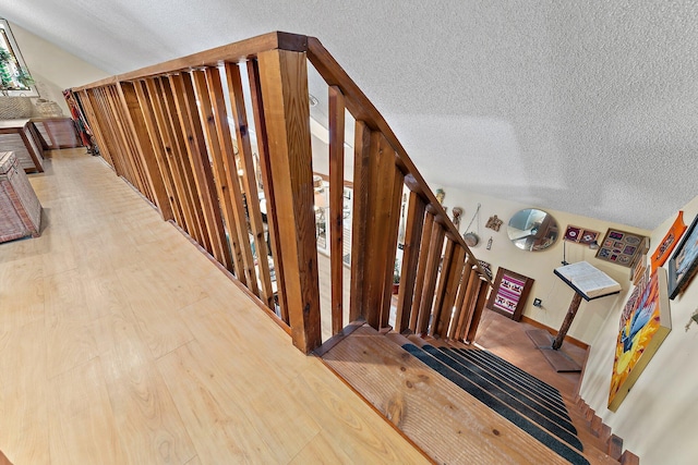 stairs featuring hardwood / wood-style floors and a textured ceiling