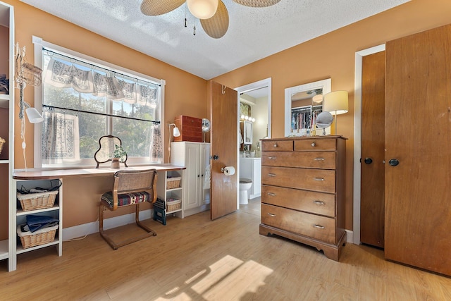 office featuring ceiling fan, light hardwood / wood-style floors, and a textured ceiling