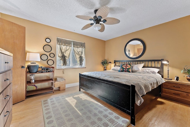 bedroom featuring a textured ceiling, light hardwood / wood-style flooring, and ceiling fan