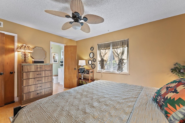 bedroom with ensuite bath, ceiling fan, and a textured ceiling