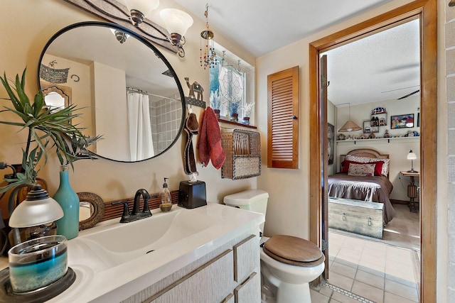 bathroom with curtained shower, ceiling fan, tile patterned flooring, toilet, and vanity