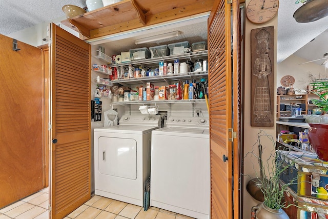 laundry room featuring light tile patterned floors, a textured ceiling, ceiling fan, and washing machine and clothes dryer