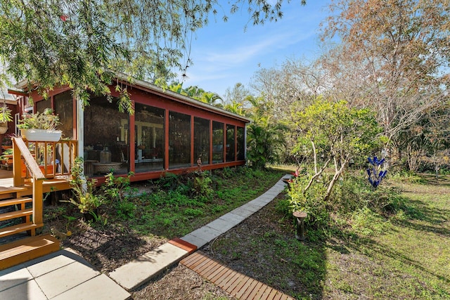 view of yard featuring a wooden deck and a sunroom