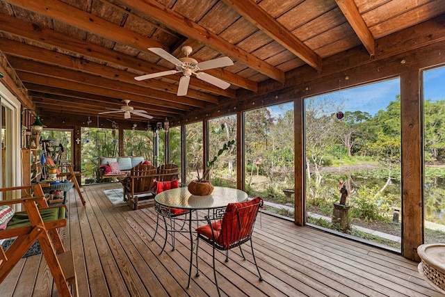 sunroom / solarium with ceiling fan and beam ceiling