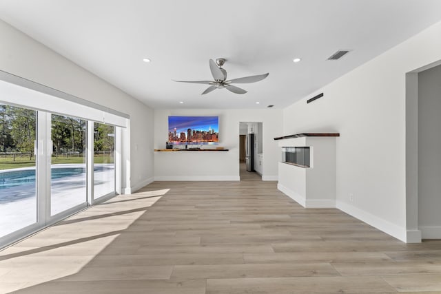 unfurnished living room featuring ceiling fan and light hardwood / wood-style flooring