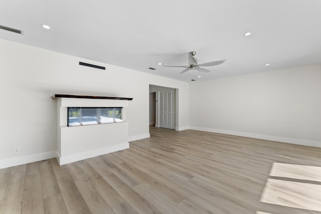 unfurnished living room featuring ceiling fan and light hardwood / wood-style flooring