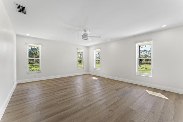 spare room with ceiling fan, light hardwood / wood-style flooring, and a healthy amount of sunlight