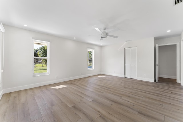 spare room featuring ceiling fan, a healthy amount of sunlight, and light hardwood / wood-style flooring