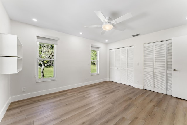 unfurnished bedroom featuring multiple windows, light hardwood / wood-style floors, and ceiling fan