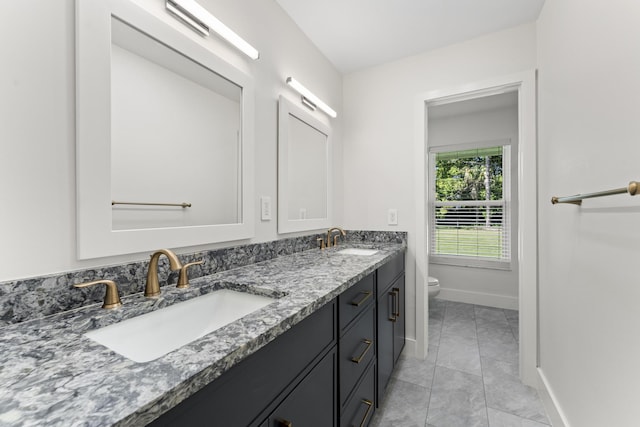 bathroom with tile patterned flooring, vanity, and toilet