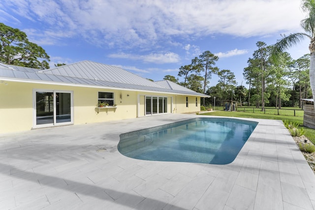 view of swimming pool featuring a patio and a lawn