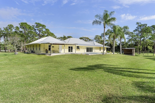 rear view of house featuring a lawn and a patio