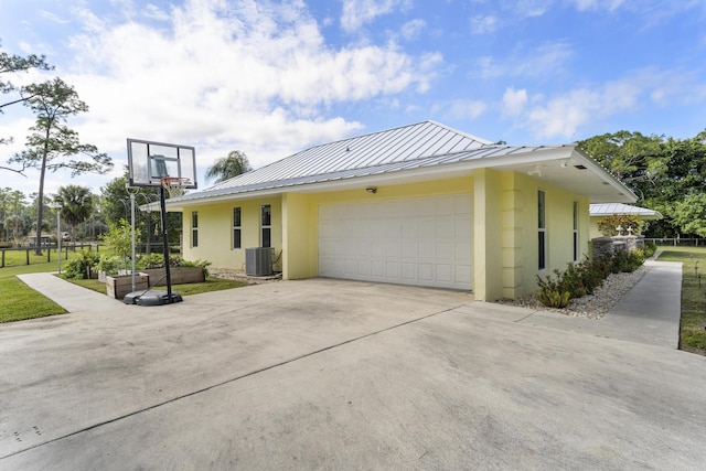 view of property exterior with a garage and central air condition unit