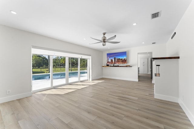 unfurnished living room with ceiling fan and light hardwood / wood-style floors