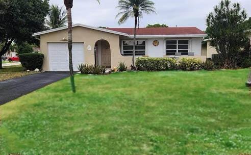 ranch-style home with a front yard and a garage