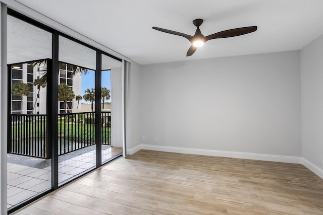 spare room featuring a wall of windows and ceiling fan